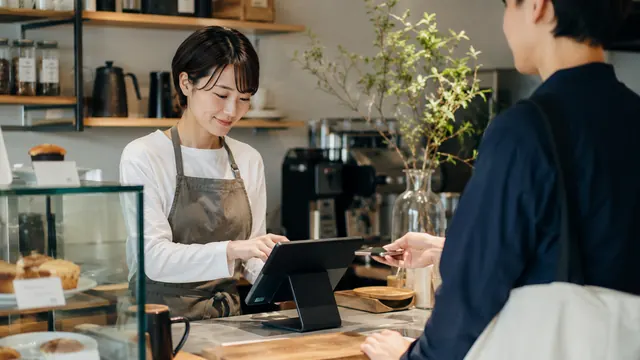 タブレットPOSを操作して会計する店員の手元